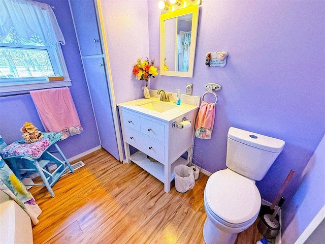 bathroom featuring vanity, wood-type flooring, and toilet