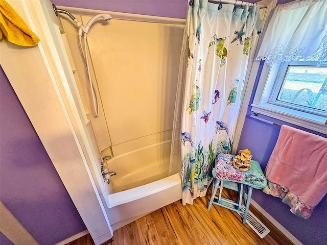 bathroom with shower / bath combo and hardwood / wood-style flooring