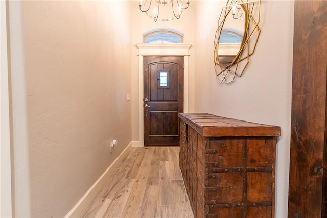 entrance foyer with light hardwood / wood-style flooring and a chandelier