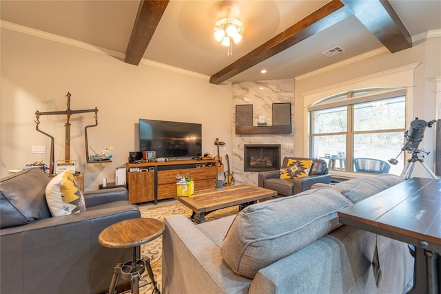 living room featuring beam ceiling, ornamental molding, and a fireplace