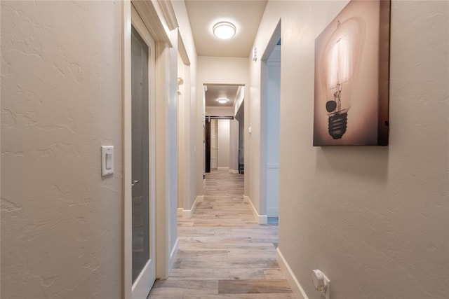 hallway with light hardwood / wood-style flooring