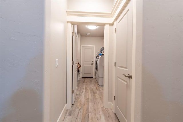 hallway featuring independent washer and dryer and light wood-type flooring