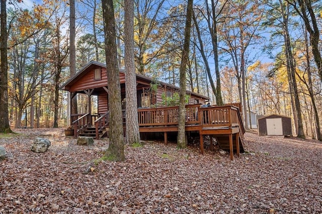 rear view of house featuring a deck and a storage shed