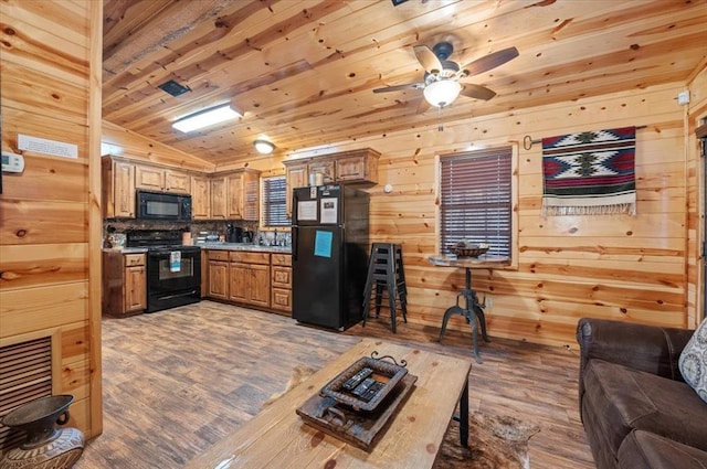 kitchen featuring tasteful backsplash, wood walls, black appliances, wood ceiling, and hardwood / wood-style flooring