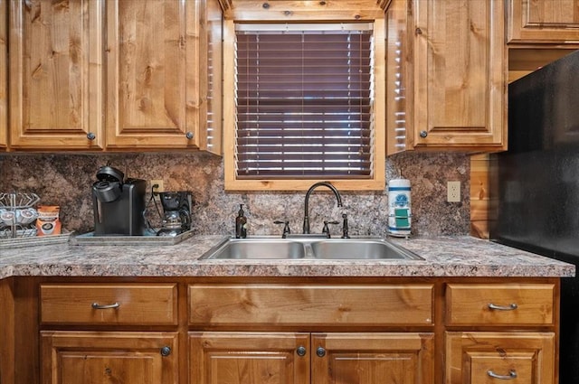 kitchen with black fridge, sink, and tasteful backsplash