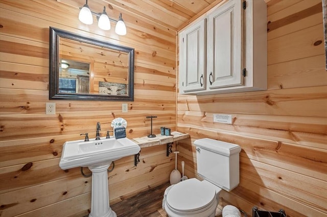 bathroom with wooden walls, wood ceiling, and toilet