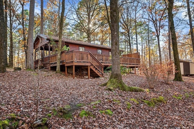 rear view of house with a shed and a wooden deck