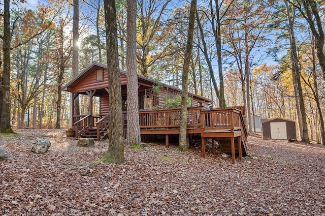 rear view of house with a deck and a storage shed