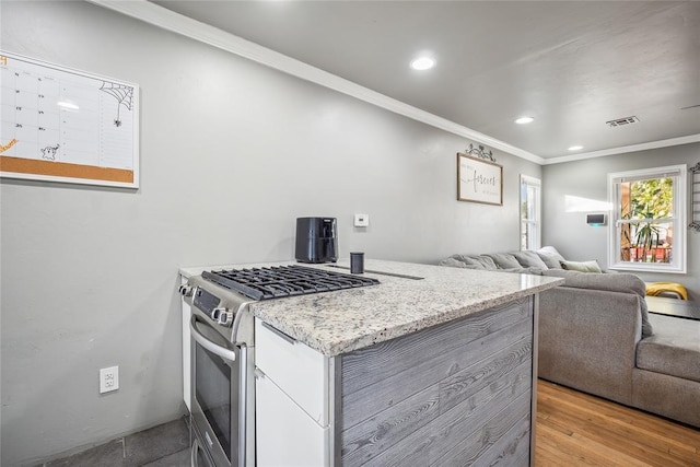 kitchen featuring light hardwood / wood-style floors, stainless steel range with gas cooktop, and ornamental molding