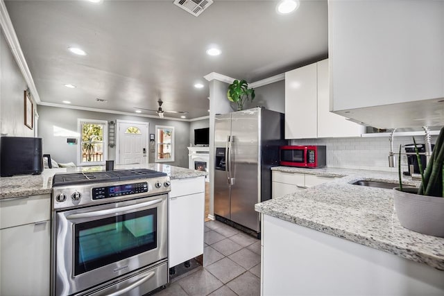 kitchen with white cabinets, sink, ceiling fan, light tile patterned floors, and stainless steel appliances