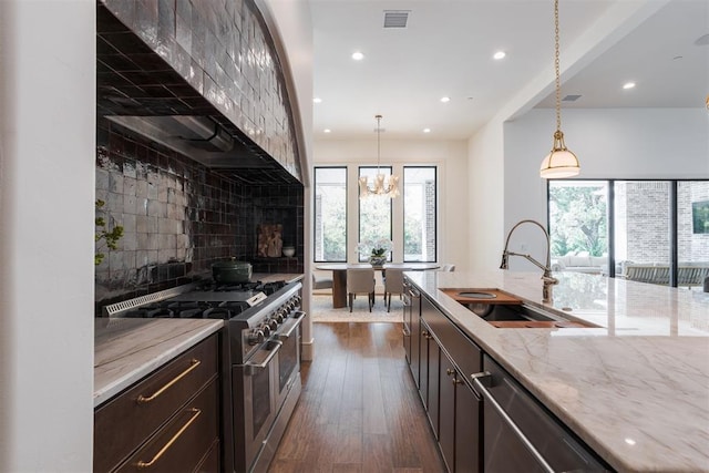 kitchen featuring decorative light fixtures, dark hardwood / wood-style flooring, light stone countertops, and appliances with stainless steel finishes