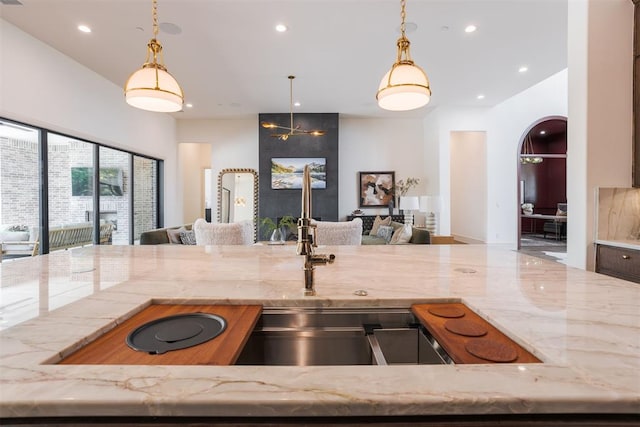 kitchen featuring light stone counters, hanging light fixtures, and an inviting chandelier