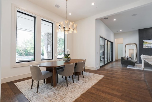 dining room with dark hardwood / wood-style flooring and a notable chandelier