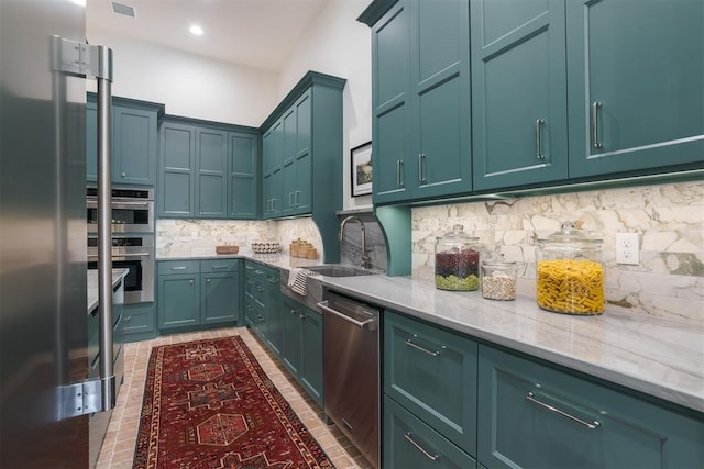 kitchen with backsplash, sink, light stone countertops, and stainless steel appliances