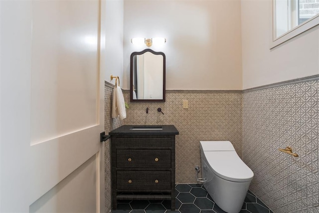 bathroom with tile patterned flooring, vanity, tile walls, and toilet