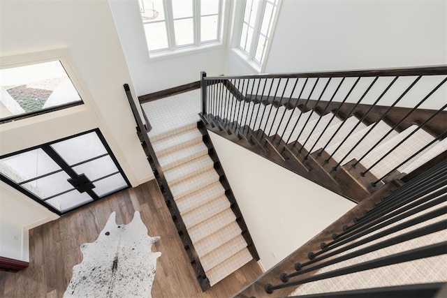 stairs with a high ceiling and wood-type flooring