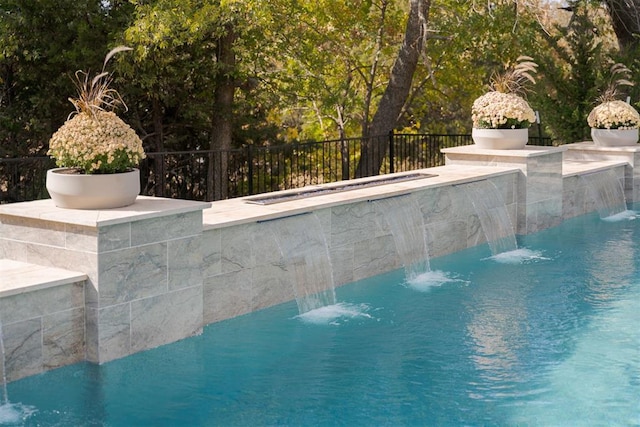 view of swimming pool with pool water feature