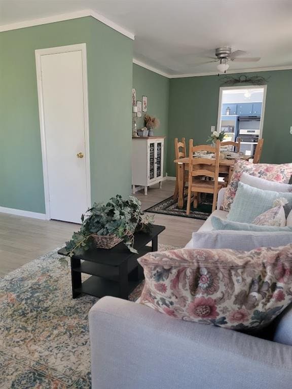 living room featuring ceiling fan, light hardwood / wood-style floors, and ornamental molding