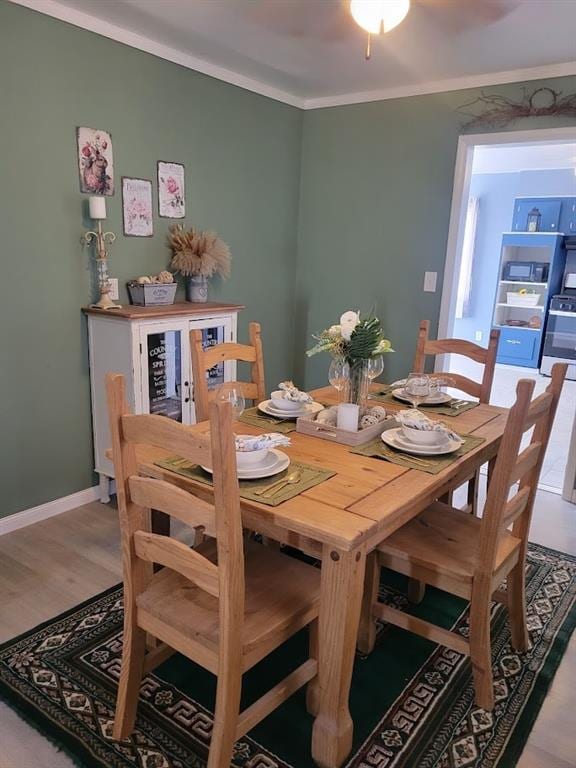 dining space with hardwood / wood-style floors, ceiling fan, and ornamental molding