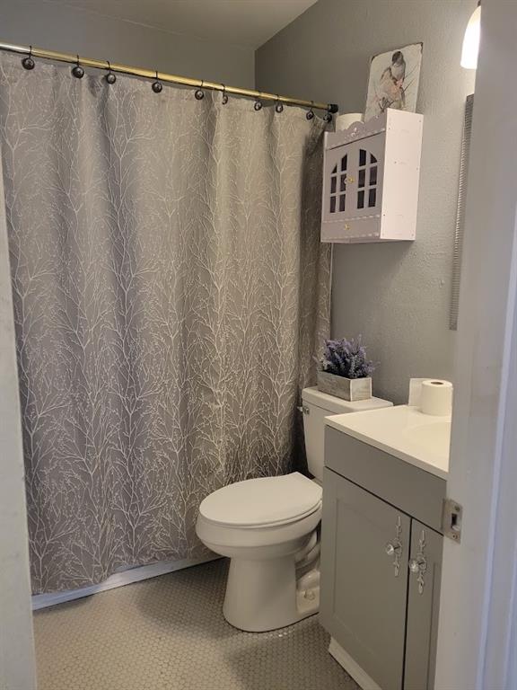 bathroom featuring tile patterned floors, vanity, and toilet