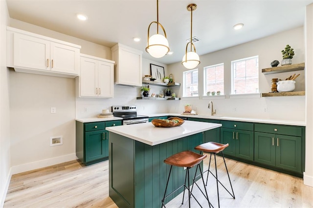 kitchen with green cabinets, hanging light fixtures, electric range, light hardwood / wood-style floors, and white cabinetry