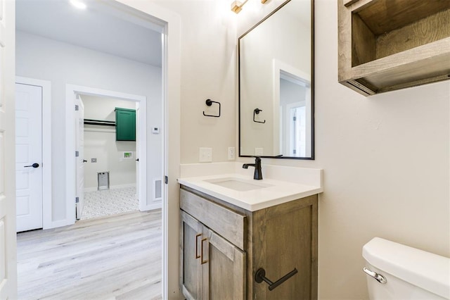 bathroom featuring toilet, vanity, and hardwood / wood-style flooring