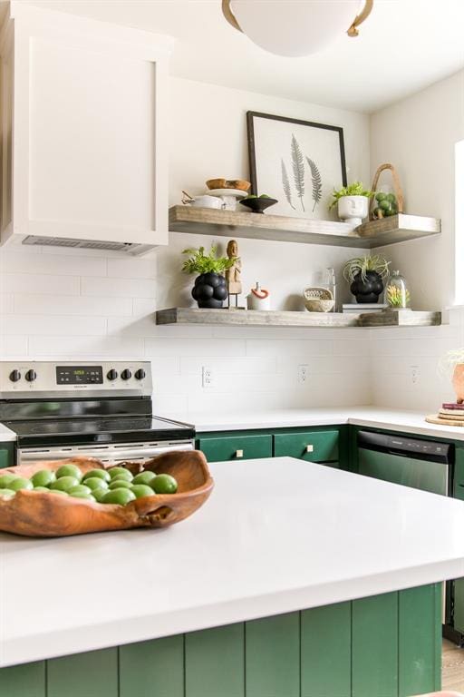 kitchen featuring decorative backsplash, green cabinets, and stainless steel appliances