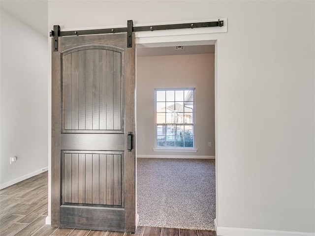 interior space featuring a barn door and wood-type flooring