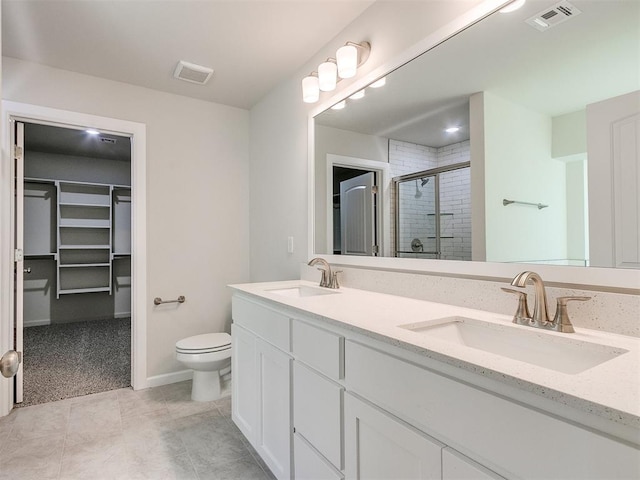 bathroom with tile patterned floors, vanity, toilet, and an enclosed shower