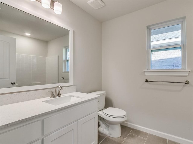 bathroom featuring tile patterned flooring, vanity, toilet, and a shower