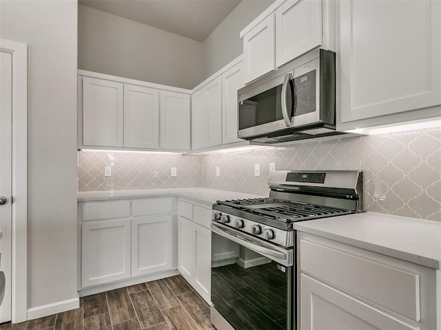 kitchen with decorative backsplash, white cabinetry, dark hardwood / wood-style floors, and appliances with stainless steel finishes