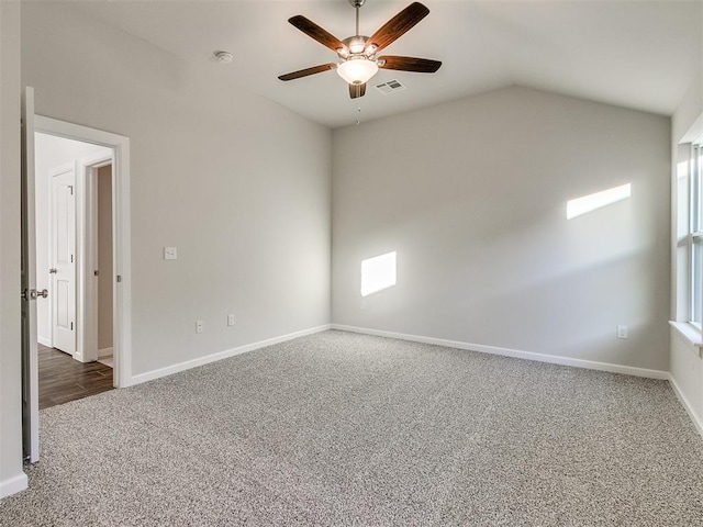 carpeted spare room featuring ceiling fan and lofted ceiling