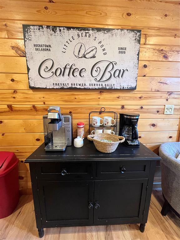 bar with hardwood / wood-style floors and wood walls