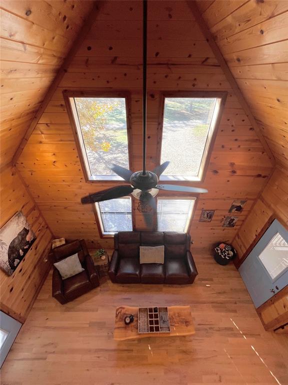 room details featuring hardwood / wood-style floors, ceiling fan, wooden walls, and wood ceiling