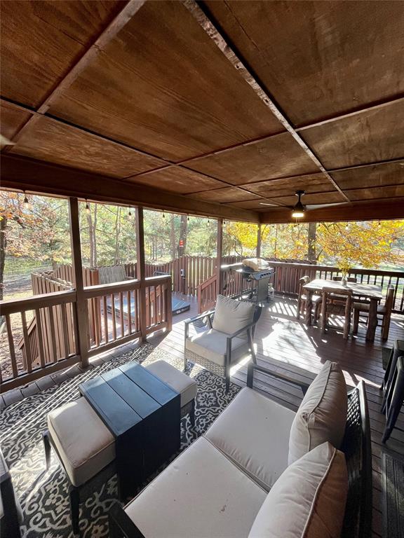 wooden terrace featuring area for grilling, an outdoor living space, and ceiling fan