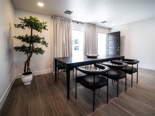 dining room featuring dark wood-type flooring and a textured ceiling