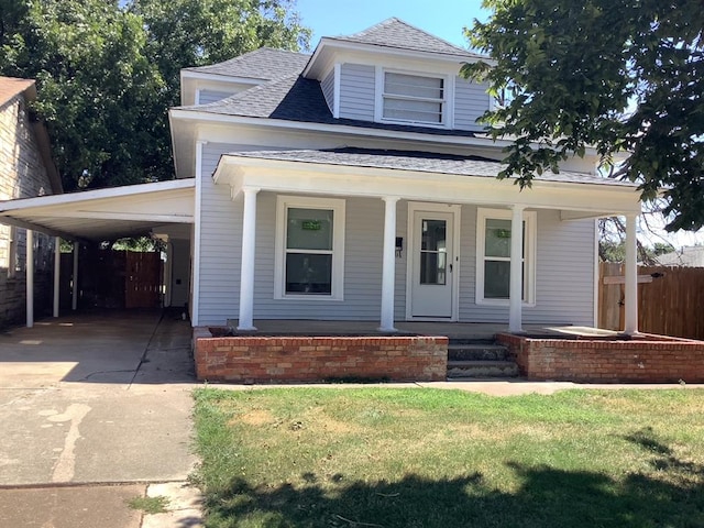 view of front of home featuring a front yard, a porch, and a carport