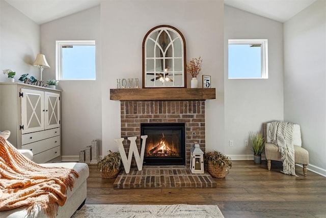 living area with hardwood / wood-style floors, lofted ceiling, and a fireplace