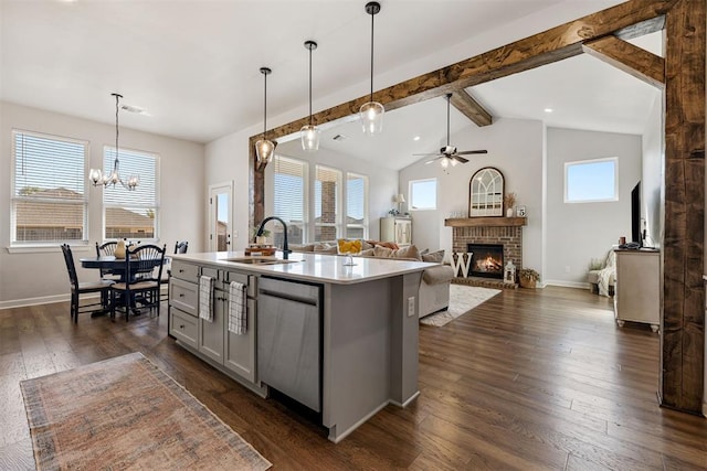 kitchen featuring a wealth of natural light, an island with sink, hanging light fixtures, and dark hardwood / wood-style floors