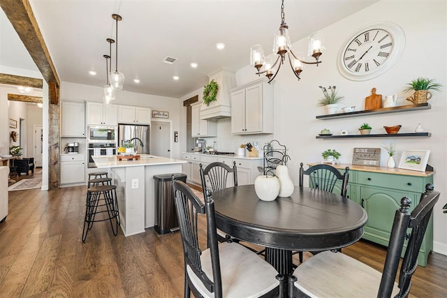 dining room featuring dark hardwood / wood-style flooring, a notable chandelier, and sink