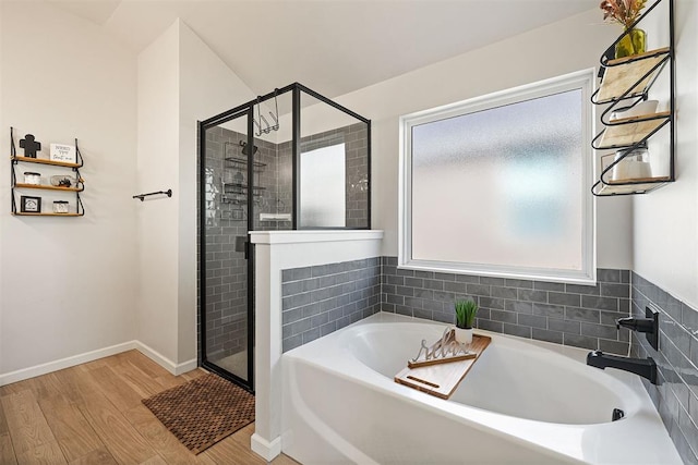 bathroom featuring hardwood / wood-style flooring, independent shower and bath, and a healthy amount of sunlight