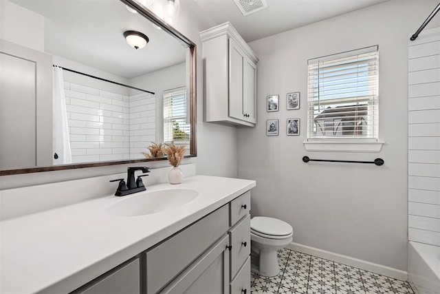 full bathroom featuring tiled shower / bath, vanity, a healthy amount of sunlight, and toilet