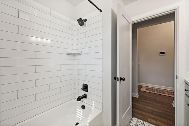 bathroom featuring hardwood / wood-style flooring, tiled shower / bath combo, and vanity