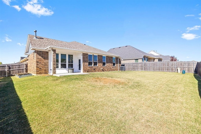 back of house with a lawn and a patio