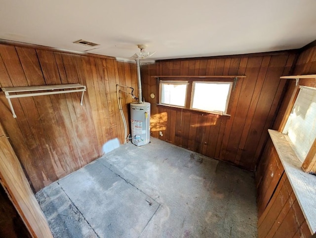 interior space featuring carpet flooring, wood walls, and water heater