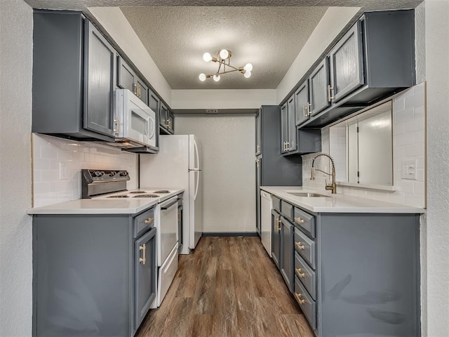 kitchen with gray cabinets, white appliances, and sink