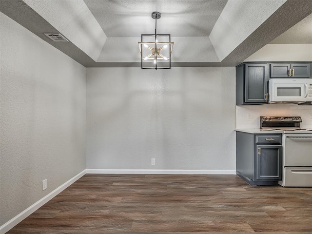 kitchen featuring electric range, gray cabinets, and a raised ceiling