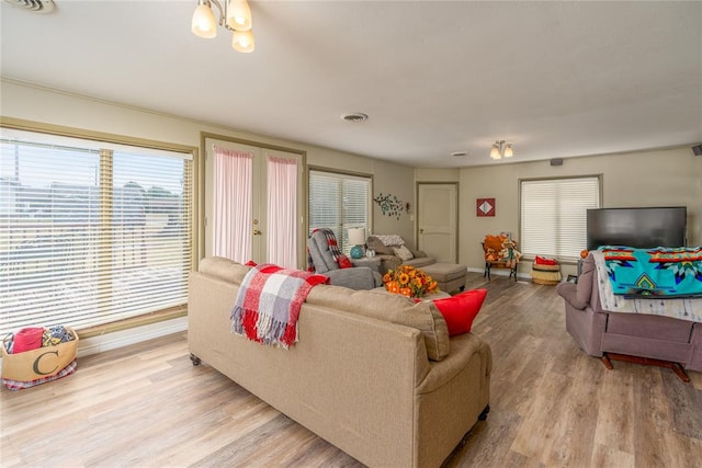 living room with an inviting chandelier and light hardwood / wood-style flooring