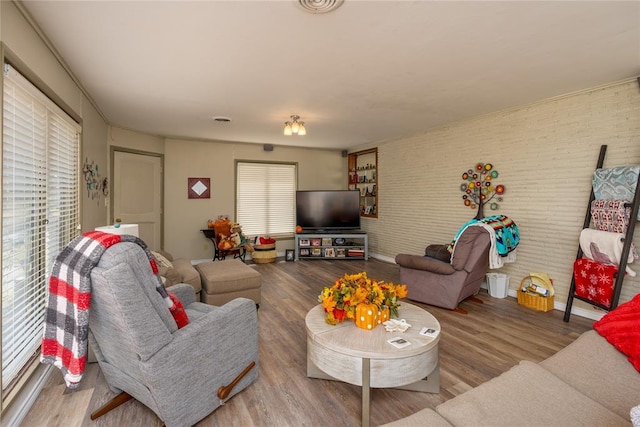 living room featuring hardwood / wood-style flooring and brick wall