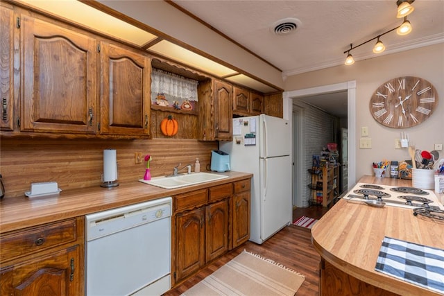 kitchen with white appliances, dark wood-type flooring, sink, decorative backsplash, and ornamental molding